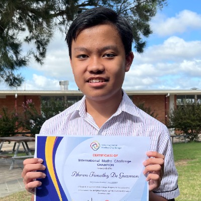 Tim De Guzman holding his International Maths Challenge Champion Certificate